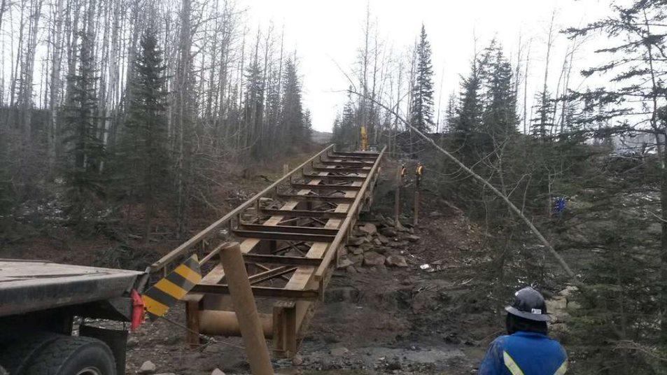 portable steel bridge being set up in forest